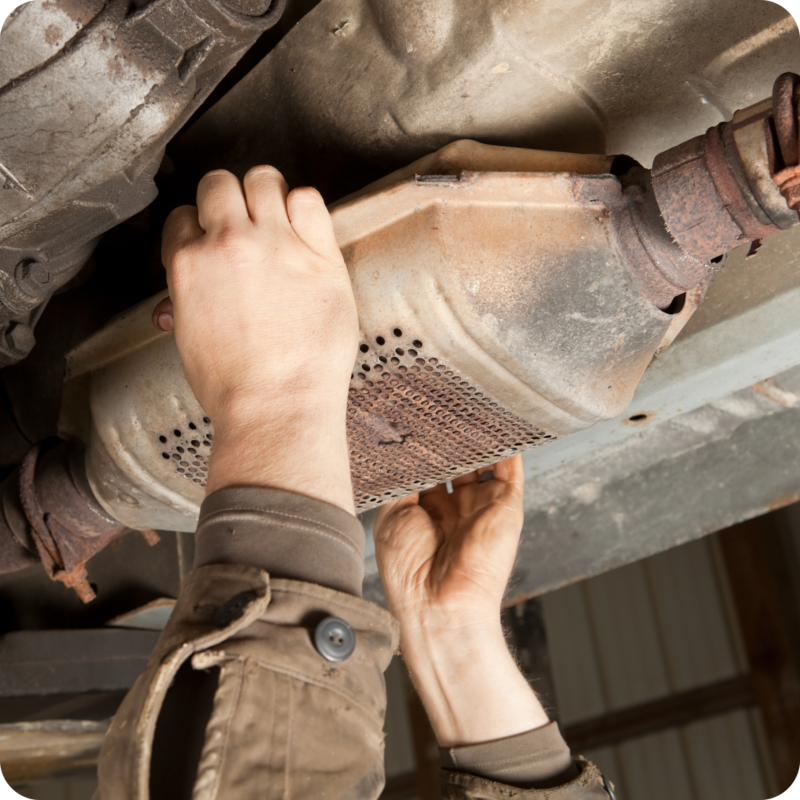 a man removing Catalytic Converter for scrap